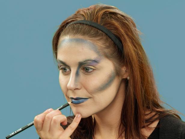 Woman lining lips for Halloween makeup
