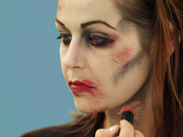 Complete your Halloween zombie look with detail work. Add a few dots of red lipstick then smear it out and away from the lips.