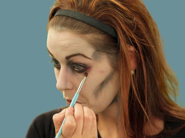 With an eye shadow brush, add some red blush near the eye and a red eye liner to the water line of the eye. This will make the zombie eyes appear tired and sickly.