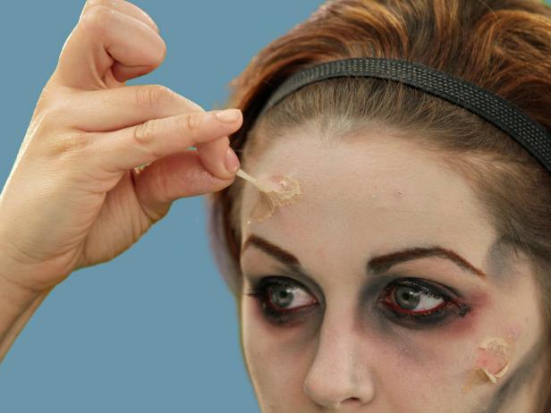 Use liquid latex to make your zombie face even scarier and create fake scars. Apply thin, dime-sized layers in various shapes and sizes on your cheek, forehead and chin. The texture gets tacky in about 20 seconds and can be pulled a little off the face to look like decaying skin.