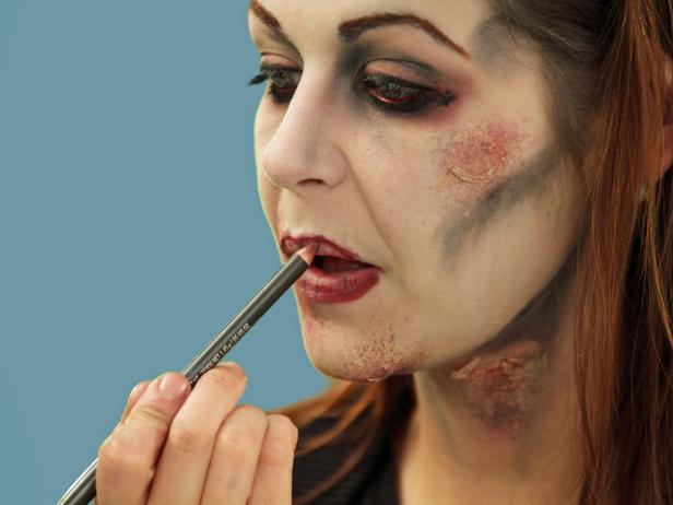 To complete your zombie look, add red coloring to the lips. Randomly add some red lip liner to the inner lips, but don't cover the black, detail lip lines.