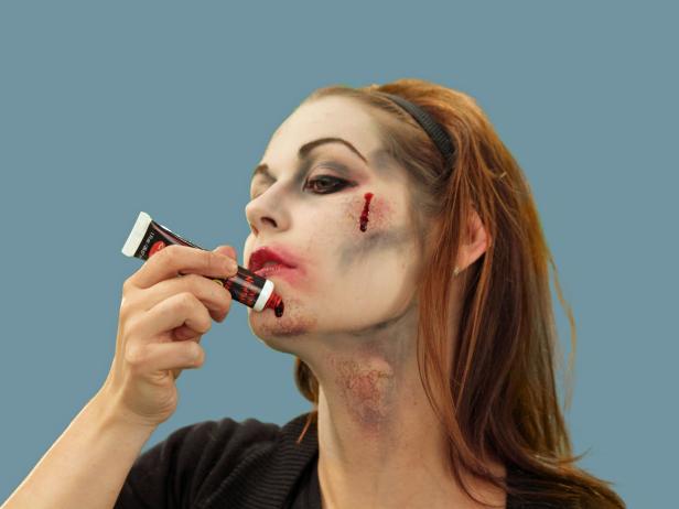 To complete the zombie Halloween look, add drips of stage blood to selected areas around the face and neck.