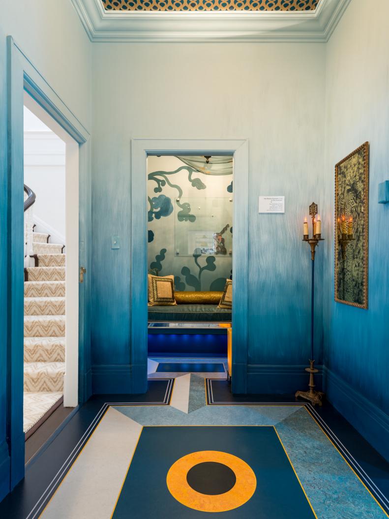 Hallway View Of Modern Bedroom With Blue Walls and Gold Accents 