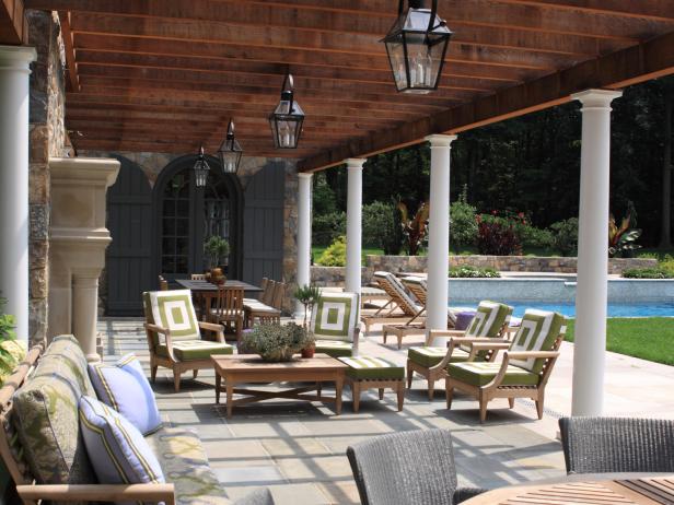 Green & White Outdoor Chairs Under Wood Pergola and Black Lanterns