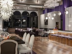 Loft With Open-Concept Floor Plan, Purple Wall and Transparent Chairs