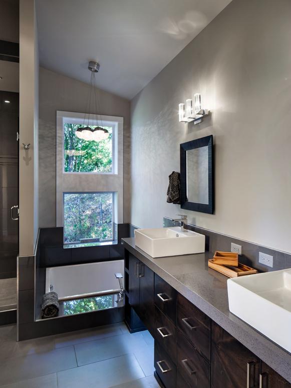 Two Vessel Sinks on Gray Vanity in Modern Gray Bathroom With Window