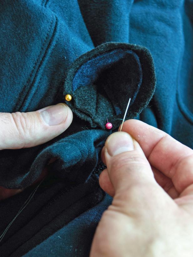Hand sew the ears in place using a needle and thread from the inside of the hood.