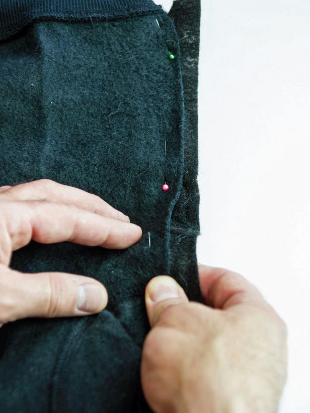 Leave the waistband and cuff intact. Place the wing in opening and pin it in place in a few spots. Turn the garment inside out and pin it along the edge for sewing. Remove the pins from the front.Use a sewing machine with charcoal thread to re-seam the garment with the wing attached.