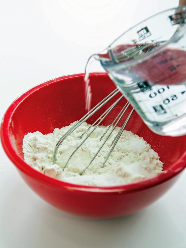 Make the flour paste by adding 1 cup flour, 1 cup water and 2 tablespoon salt to a bowl. Mix until smooth and the consistency of thick pancake batter. Place torn strips of newsprint in the bowl and pull them out running them between two fingers pressed together to remove any excess paste. Quickly add the strips to the surface of the box. Overlap each strip just a bit to make sure you have full coverage. Each side can get two coats, but no more. The more secure the edges, the harder it will be for your guests to bust the pinata open. When the first side is dry carefully turn it over and cover the other side. Dry completely before proceeding.