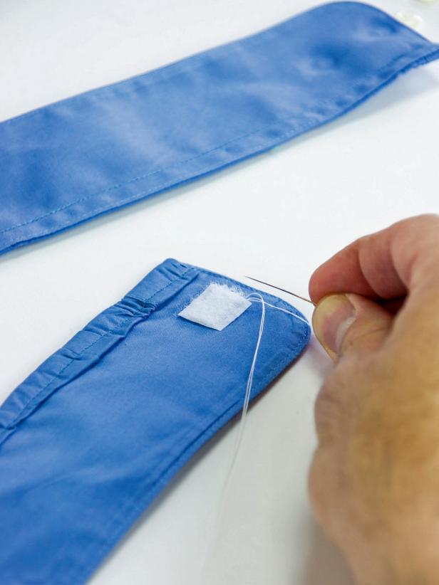 Sew Hook and Loop Tape to the back of each button hole only attaching it to the back piece of fabric.