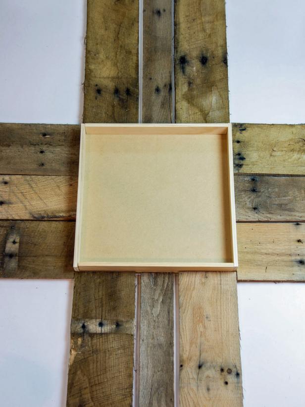 Break apart the pallets and cut into 12 – 16 pieces, 22” long, and 3 – 4 pieces, 17 inches long. Cut the wood strips (2) at 15” and (2) at 14-1/2”. 
Place pallet pieces on the floor with the 15”x15” mdf board.