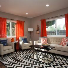 Taupe Living Room With Orange Curtains and Chevron Rug