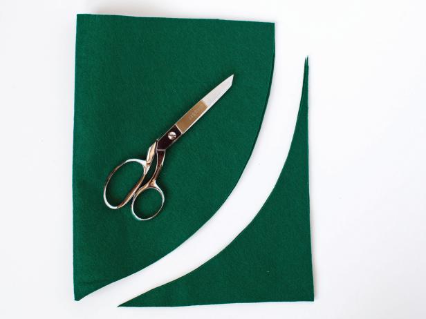 Cut a piece of felt to be about 12 inches by 18 inches and fold it in half width wise.Starting at the top right folded corner, draw an arched line coming down toward the bottom left (non folded corner), ending about 3 inches from the bottom corner of the paper.