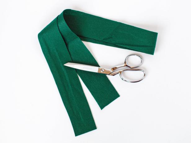 Then, cut a small opening on the folded side for the child’s head to be able to slip the tunic over his head.Cut a long length of green felt to act as a belt to tie around the tunic.
