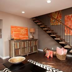 Taupe Living Room With Staircase and Rustic Cabinet