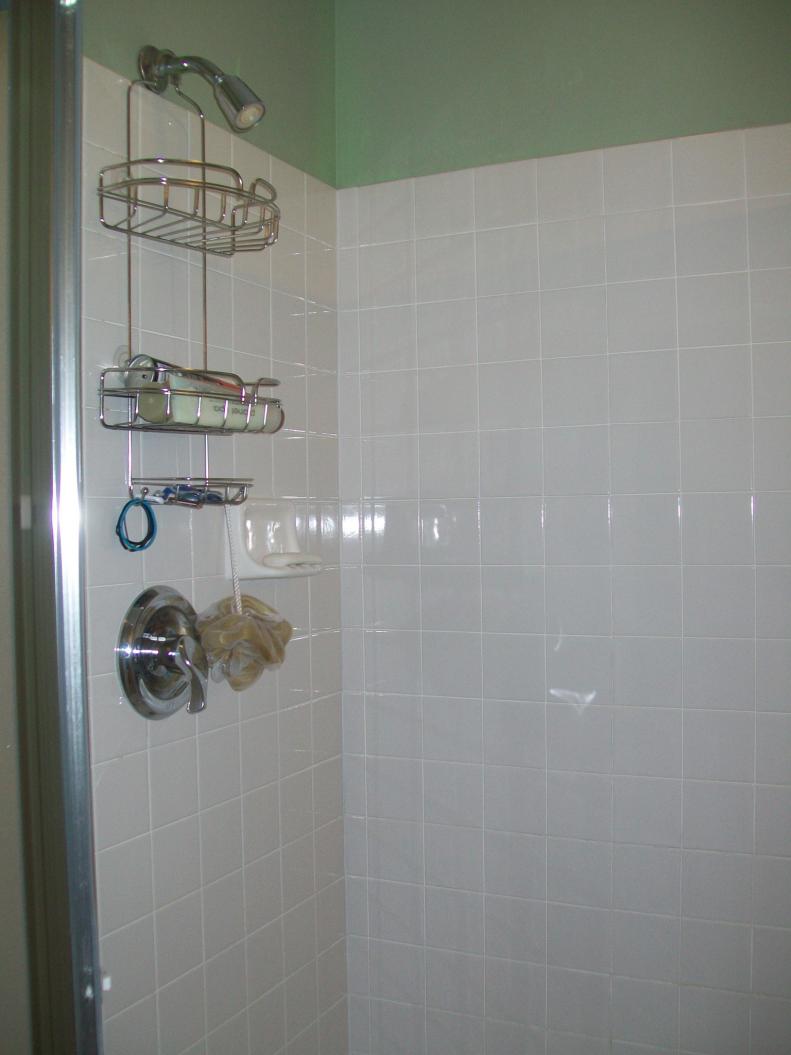 Before the remodel, the shower was small and lackluster, with frosted glass walls and a basic showerhead.