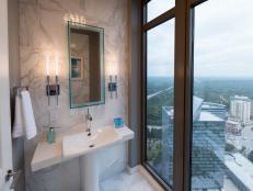 Surrounded by Carrera marble and stunning city views, the powder room hints to the apartment's lavish style.
