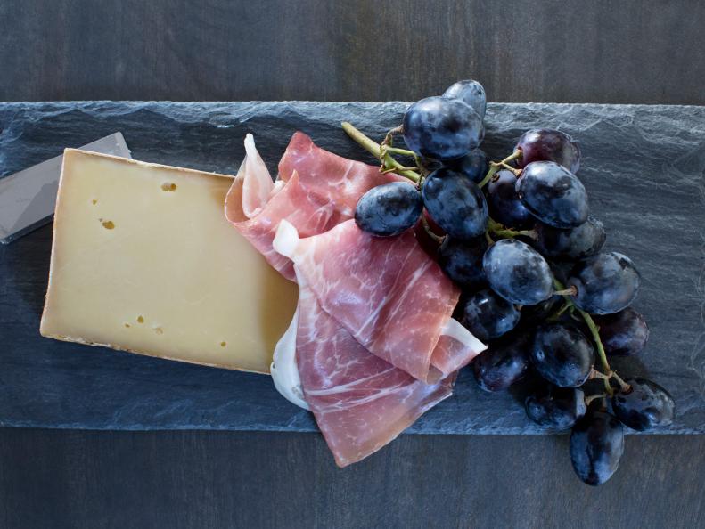 Fontina, prosciutto and grapes on slate
