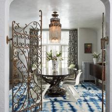 Ornate Metal Gate Door Opens to Eclectic Dining Room