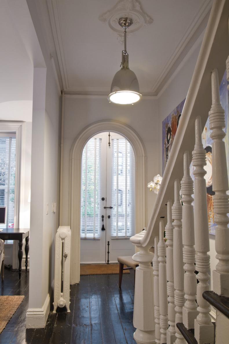 White Foyer With Arched Doorway, Nautical Pendant, Dark Hardwoods