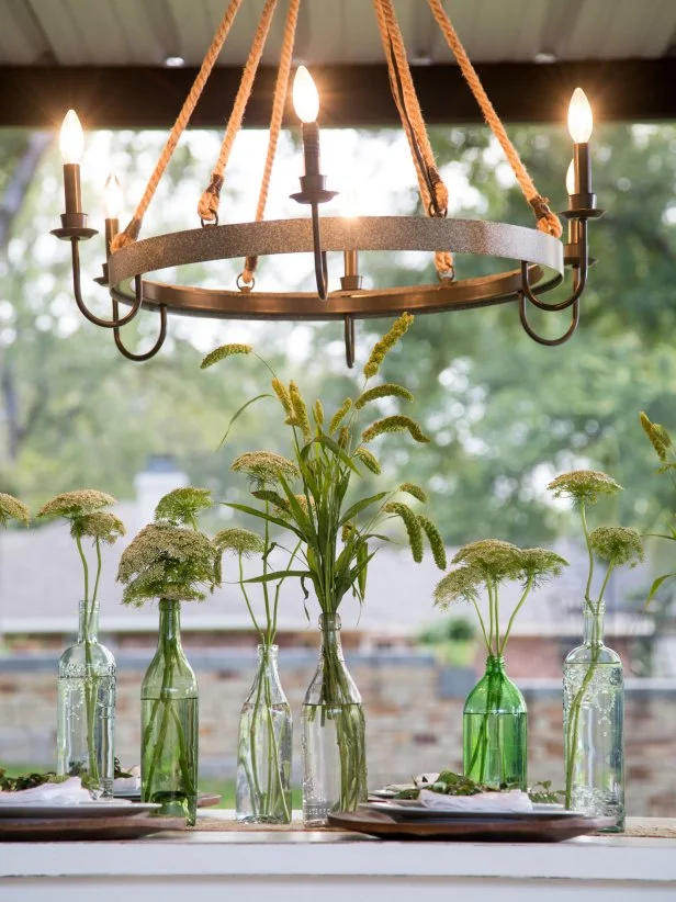 The outdoor dining area gets a rope and metal chandelier to light up the space.