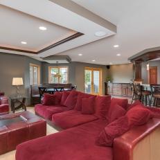 Transitional Home Theater Features Striking Red Sectional, Armchair & Ottoman