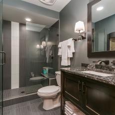 Transitional Bathroom In Gray Tones Features A Handsome Vanity With Marble Top & Shower With Sleek Glass Tile