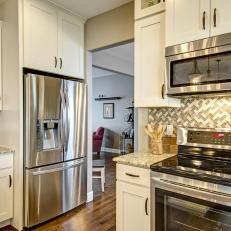 Welcoming Traditional Kitchen Features Chevron-Design Backsplash & Marble Countertop In Soft Colors