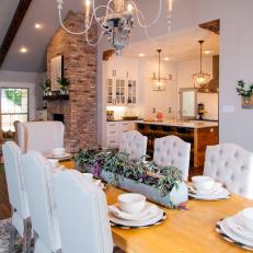 Dining Room With Chandelier and White Upholstered Chairs