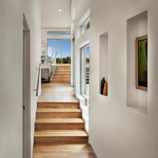 Modern Hall Leading to Backyard With Hardwood Floor and Steps and White Walls 