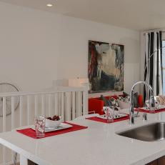 Bright Kitchen Island With Polished White Countertop and Red Accents