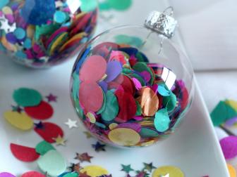 A fun DIY project for the kids, these confetti ornaments are a party for your tree. Use store bought confetti or have the kids punch some out with a hole punch. Carefully fill each glass ornament with the confetti pieces. Add in a few metallic stars for an extra holiday sparkle.