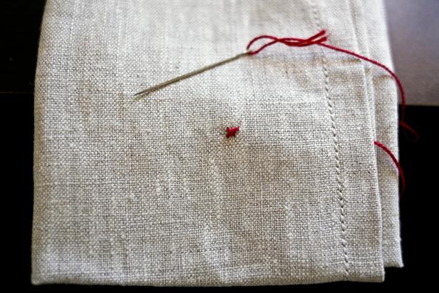 red cross stitched "X" on a napkin