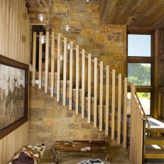 Natural Wood Staircase With Exposed Stone Wall