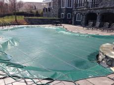 In-ground pool with winter cover in place