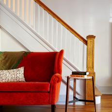 Burnt Orange Loveseat Finds Home Against Stairwell in Townhome