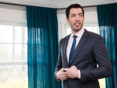 Host Drew Scott poses for a portrait in the living room of Angela and Ro's new home. The room has jewel-toned accessories and bright yellow chairs, which set off the neutral paint and couch colors, as seen on Property Brothers. (Portrait)