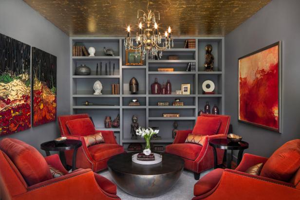 Gray Home Library With Gold Ceiling, Red-Orange Chairs and Chandelier