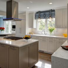 Neutral Kitchen With Island and Color-Changing Vent Hood