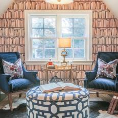 Bookshelf Wallpaper in Eclectic Sitting Room With Two Navy Blue Armchairs and Gold Wet Bar Cart 