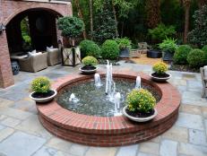 A property renovation transforms an underutilized yard into a woodlands area with a southern courtyard, fountain and entertainment space