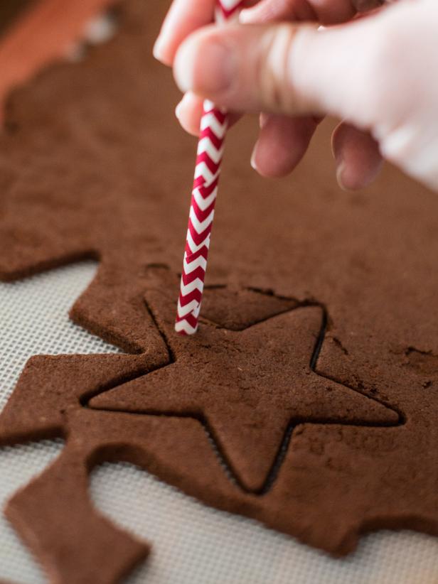Use cookie cutters in desired shapes to cut out ornaments, like cookies. A knife can also be used to hand-cut custom shapes or dough can be sculpted like play dough. Once desired shapes are created, use a straw to make a hole at the top of each ornament for threading a ribbon or string through.