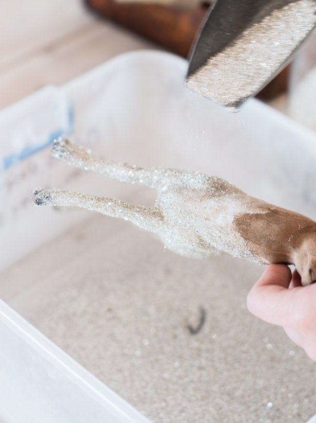 Pour glitter over wet glue until coated. Shake off excess glitter, allowing it to fall into a container to reuse. Repeat steps one and two until entire surface is covered in glitter. Allow glue to dry for about an hour before handling. Tip: German glass glitter will tarnish over time, so wrap it in tissue and put it in a lidded box when the holidays are over, so it stays sparkly for years to come.