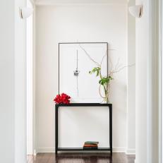 Bright, Modern Hallway Design With Dark Hardwood Flooring, White Walls and Modern Artwork 