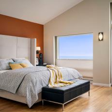 Breezy Transitional Bedroom With Deep Orange Accent Wall, Large Tufted Headboard with Folded Edges and Accordion Window Shades