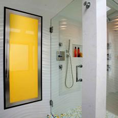 Bright Yellow Built In Cabinet in Textured Waved Wall Next To Glass Enclosed Shower in Contemporary Bathroom 