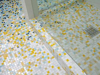 Close Up on Small Gray, White and Yellow Tile Bathroom Floor With Fading Effect of Navy and Light Blue 