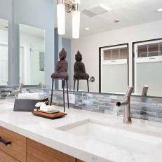 Bright Asian Vanity With Double Sinks in Marble White Countertop With Small Tile Backsplash Strip and Buddha Statue 