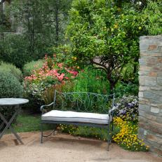 A Wrought Iron Settee and Table Make A Garden More Contemplative