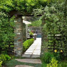 A Stonework Archway Hides Inside a Lush Garden Trellis